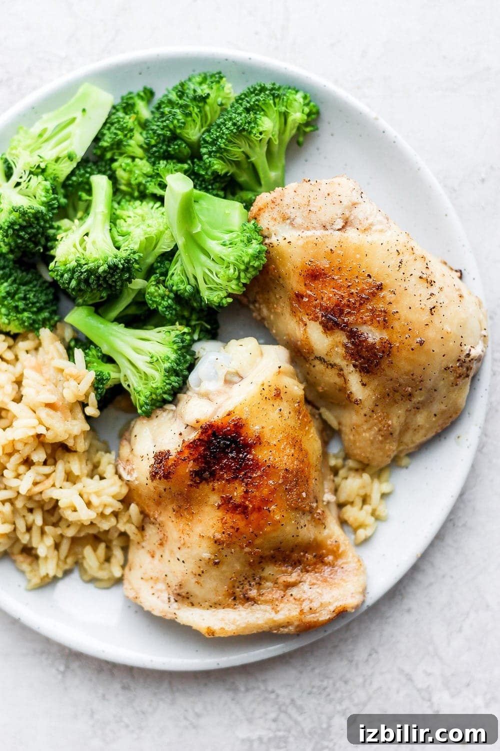 Golden brown sous vide chicken thighs are a perfect weeknight meal! chicken thighs on plate with rice and broccoli