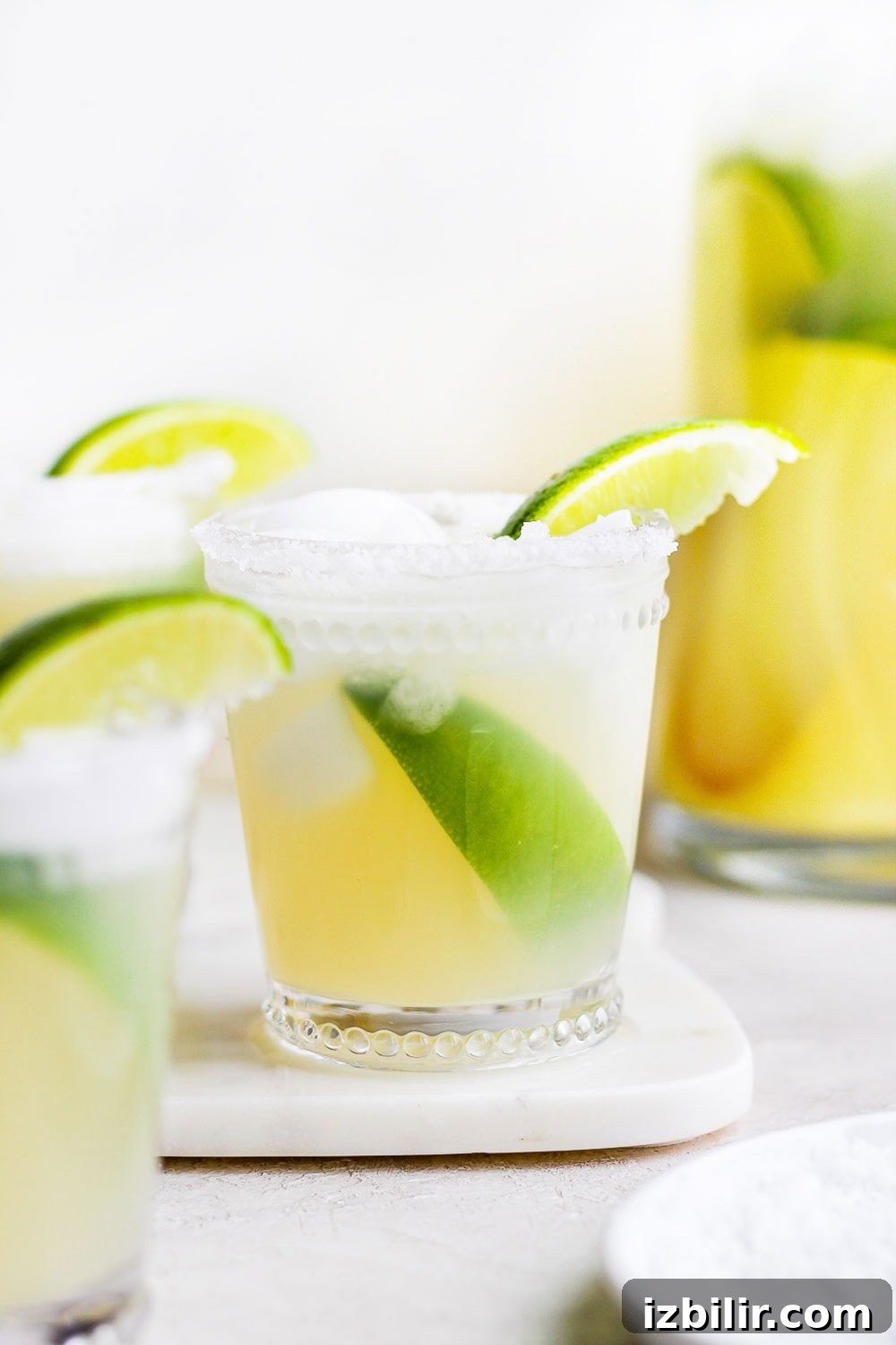 This is the BEST skinny margarita on the internet and it's made with 4 simple ingredients - tequila, fresh lime juice, ice, and honey/agave simple syrup! margarita in glass with limes