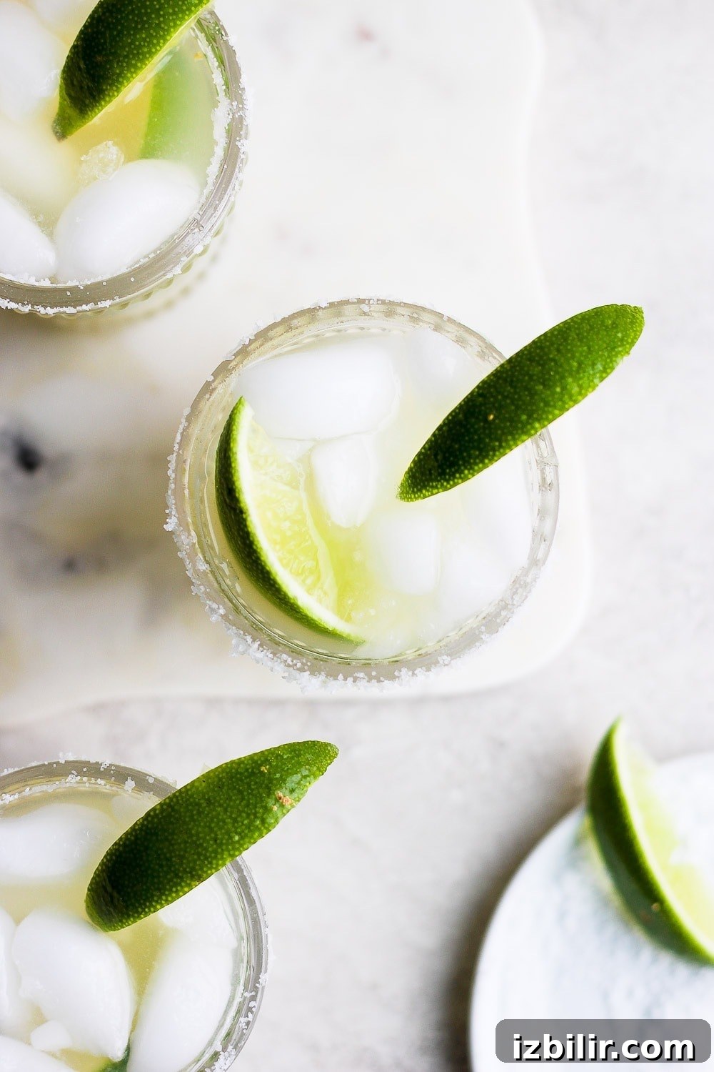 This is the BEST skinny margarita on the internet and it's made with 4 simple ingredients - tequila, fresh lime juice, ice, and honey/agave simple syrup! margaritas in glass with lime