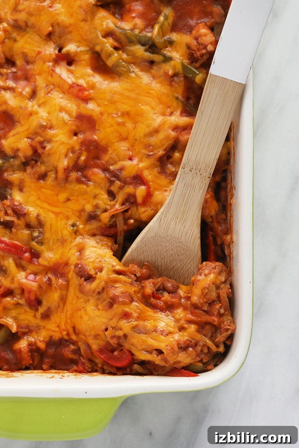 Served Chicken Burrito Bowl Casserole chicken burrito bowl casserole being scooped out of a casserole dish with a serving spoon