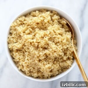 How to Cook Fluffy Quinoa Every Time 2 A guide on how to make quinoa served in a white bowl with a gold spoon.