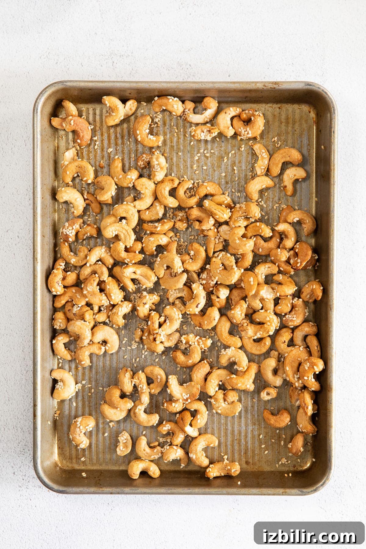 roasted cashews on a pan with sesame seeds