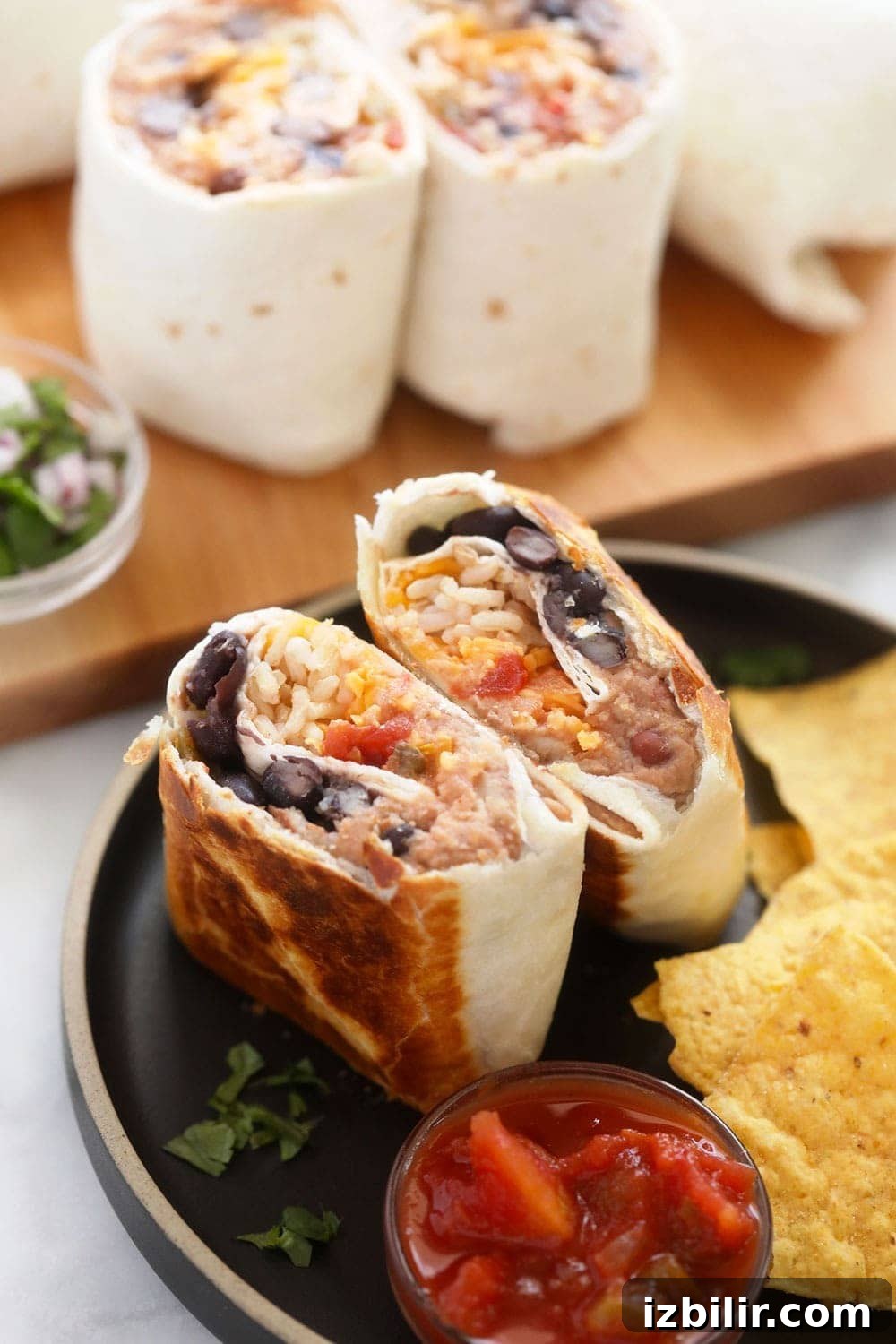 bean burrito on plate with chips Make-ahead bean burritos that use only 6 pantry staple ingredients. You will adore this bean and cheese burrito recipe at work, home, or on-the-go!