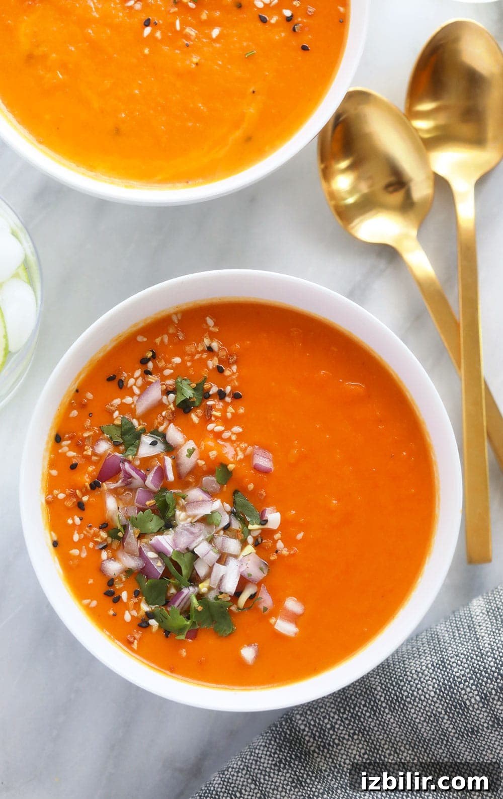Instant Pot sweet potato carrot ginger soup in a bowl topped with diced onion