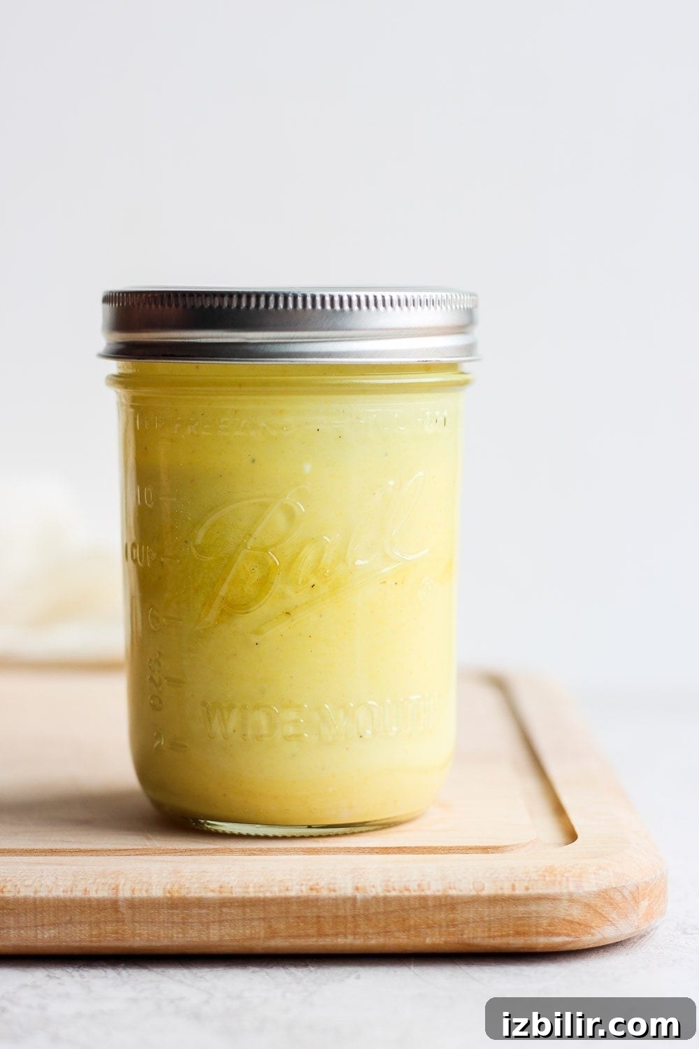 honey mustard dressing in jar on cutting board