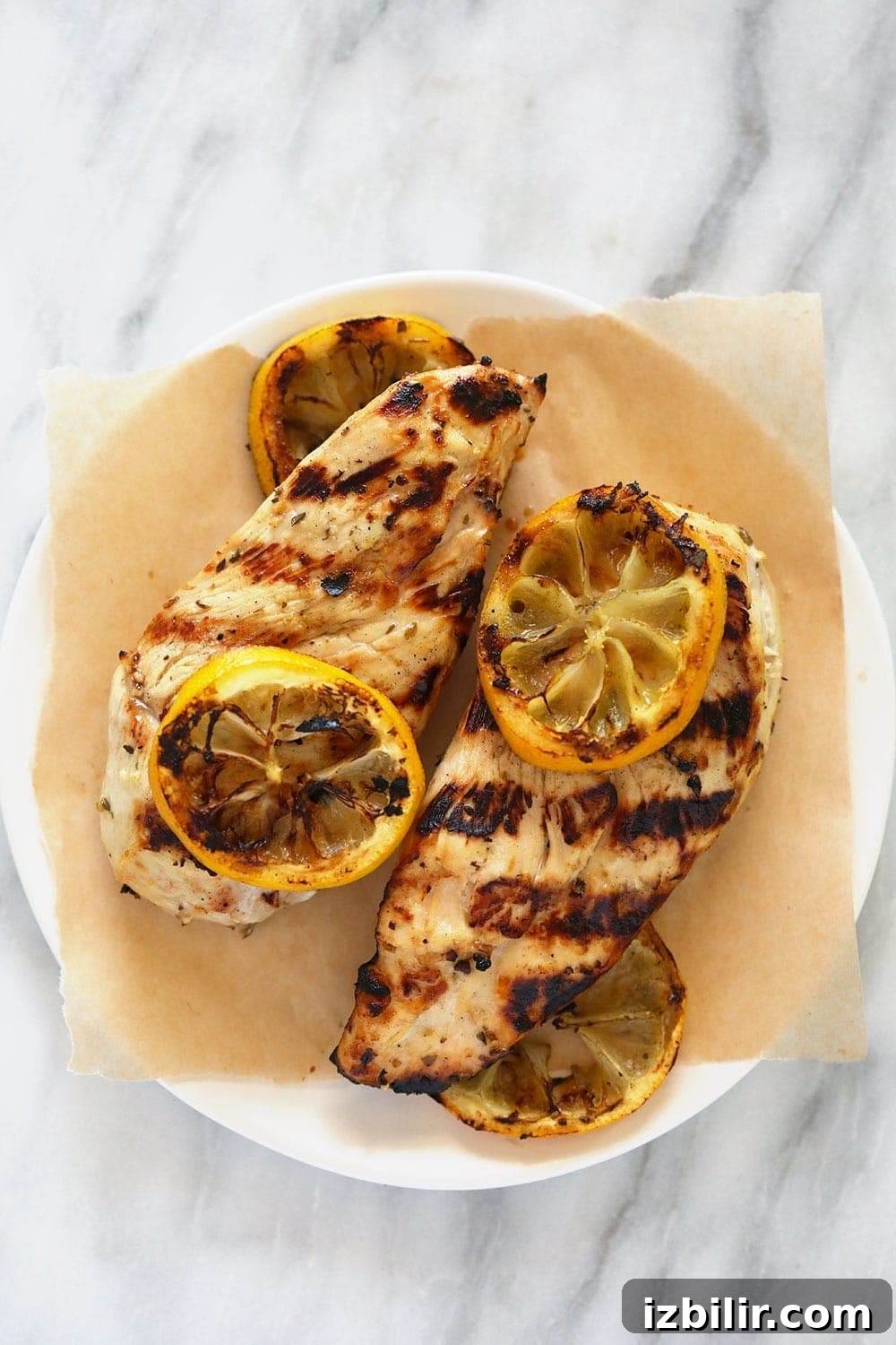 Marinated Greek chicken is the perfect summer meal. Use Greek salad dressing to marinate chicken breast for a flavorful and delicious chicken dinner! Greek lemon chicken with lemon slices.