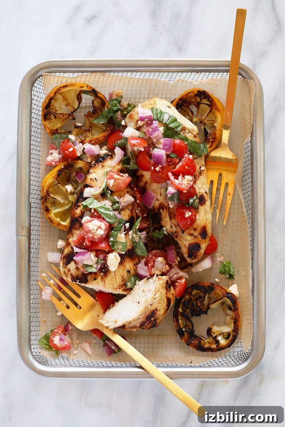 Add fresh Greek salad to grilled lemon chicken and you get a delicious and healthy chicken dinner! Grilled lemon chicken with Greek salad in a basket.