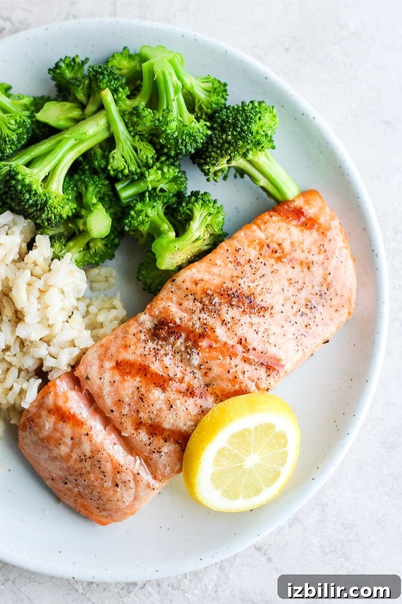 Served grilled salmon Grilled salmon on a plate with broccoli and rice.