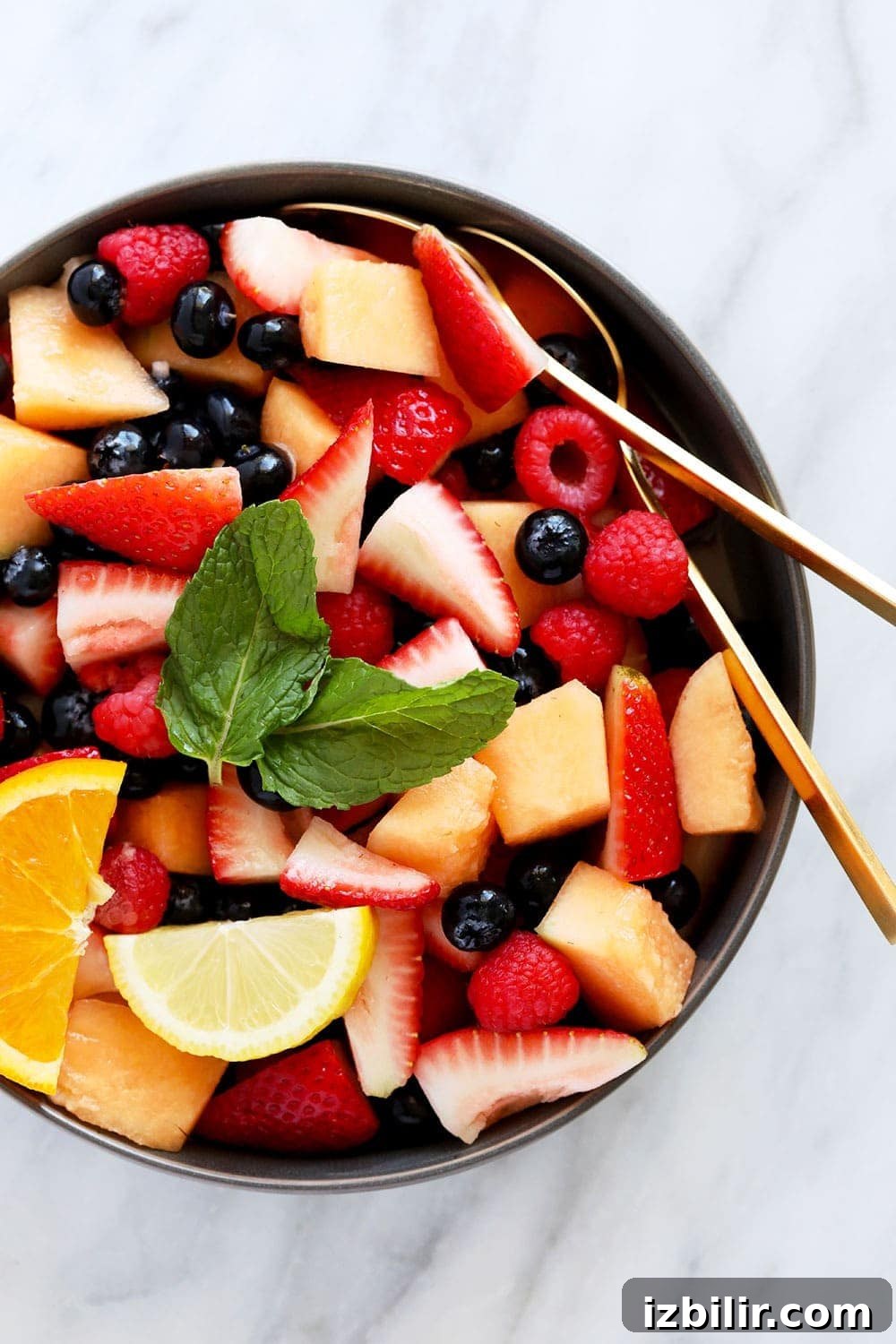 beautiful fruit salad recipe in a bowl topped with fresh mint