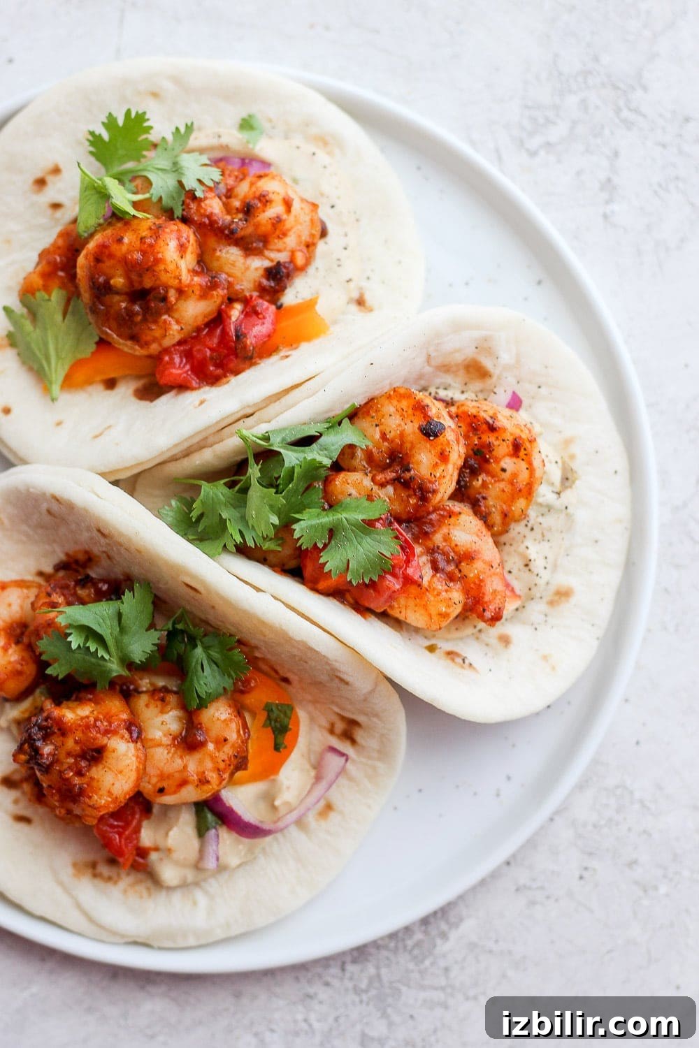 These shrimp tacos are the ultimate easy weeknight meal! shrimp tacos topped with cilantro on a plate