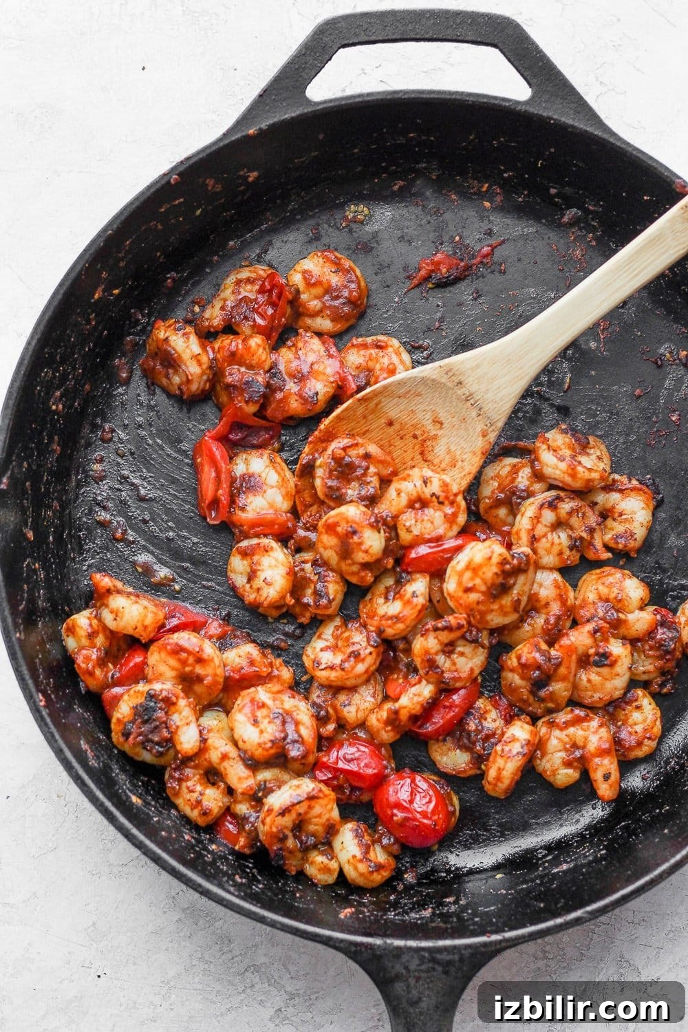 Pan-searing shrimp keeps them tender and flavorful. shrimp being cooked in a cast iron skillet