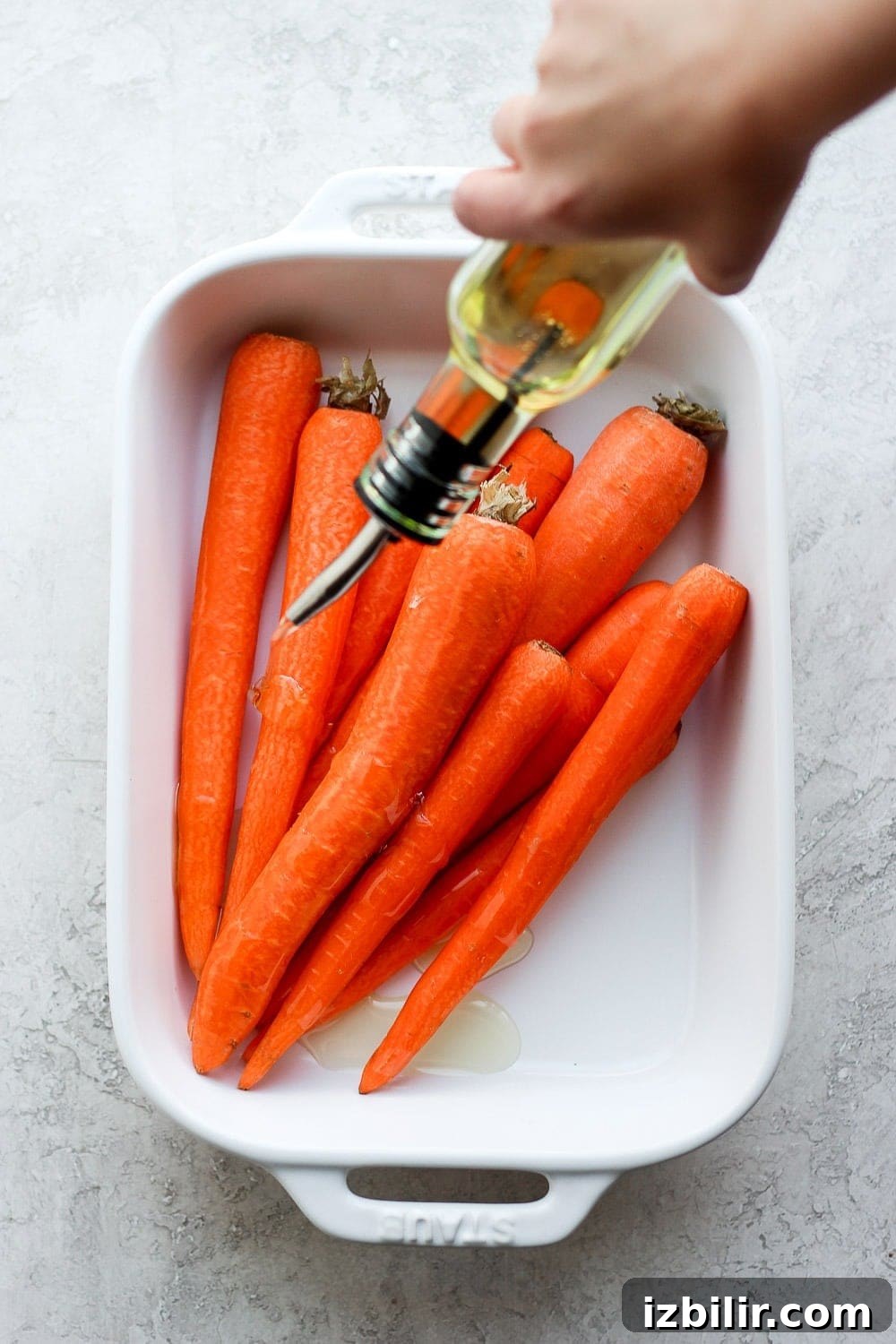 Drizzling carrots with olive oil