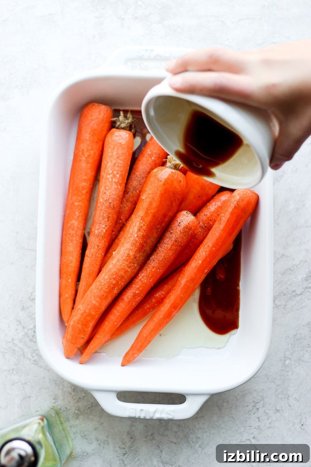 Pouring marinade over the carrots.