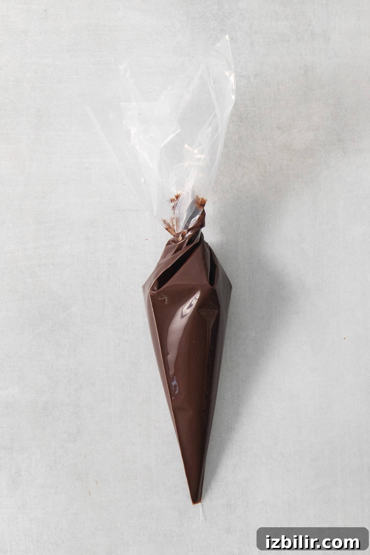 How to Make Homemade Vegan Chocolate Chips 4 A cone of chocolate wrapped in plastic on a concrete surface.