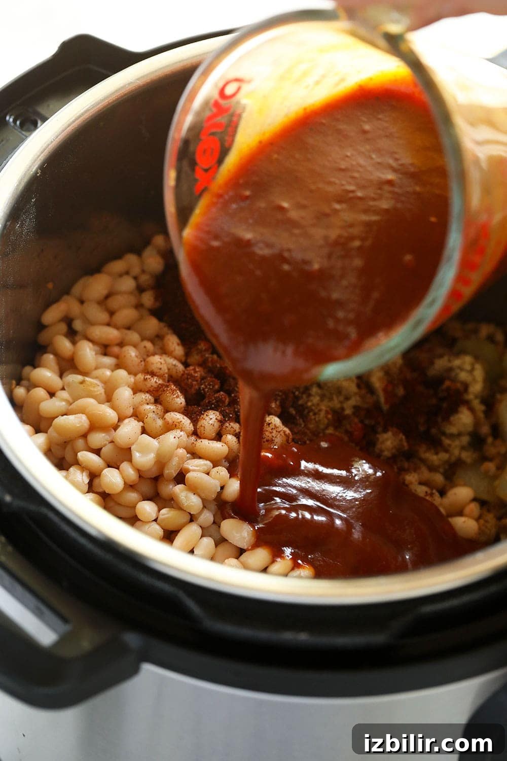 Pouring BBQ sauce into the Instant Pot.