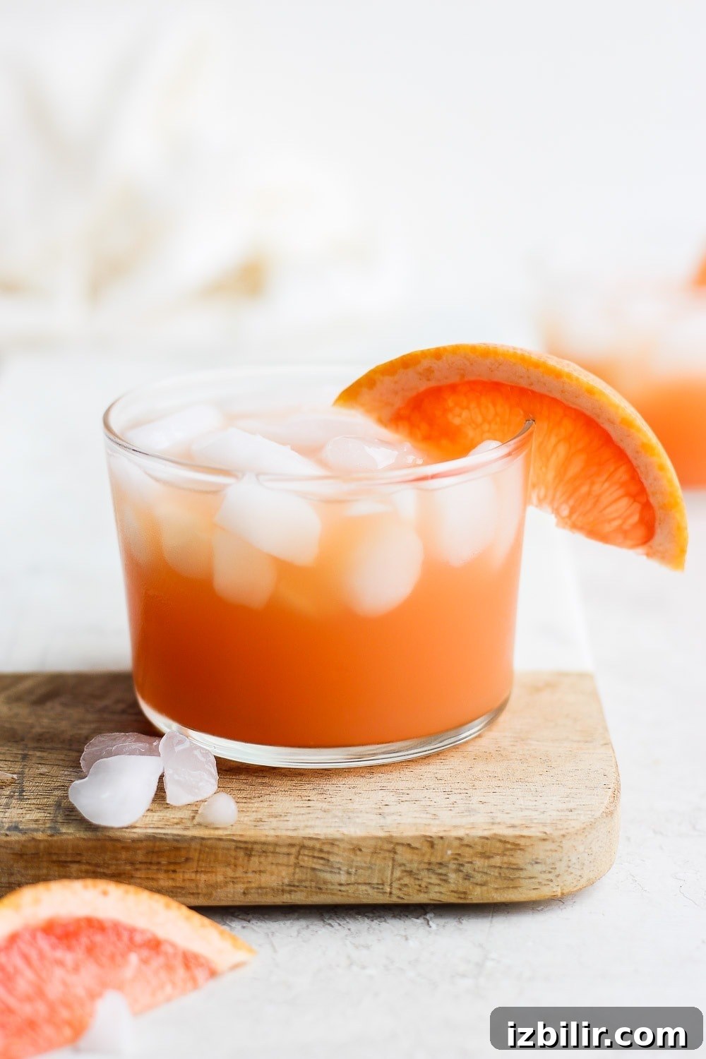 Try this refreshing grapefruit Paloma cocktail. It's made with fresh grapefruit juice, tequila, sour soda, and a squeeze of lime! paloma cocktail with a slice of grapefruit garnished on the edge of the glass