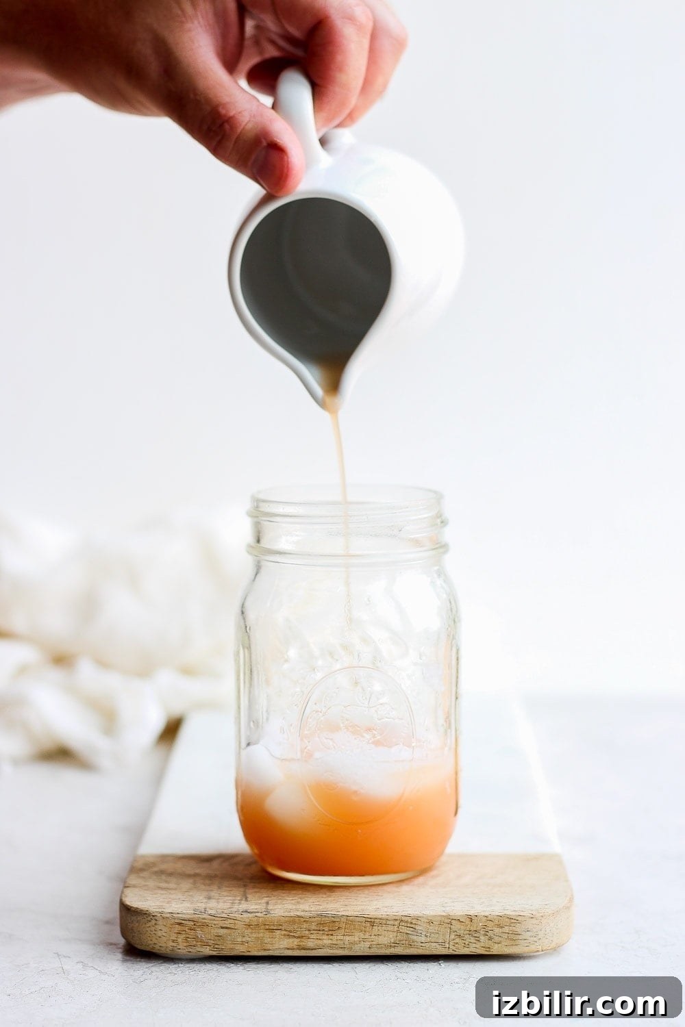 Try this refreshing grapefruit Paloma cocktail. It's made with fresh grapefruit juice, tequila, sour soda, and a squeeze of lime! grapefruit juice for paloma cocktail being poured into a mason jar before being shaken to perfection