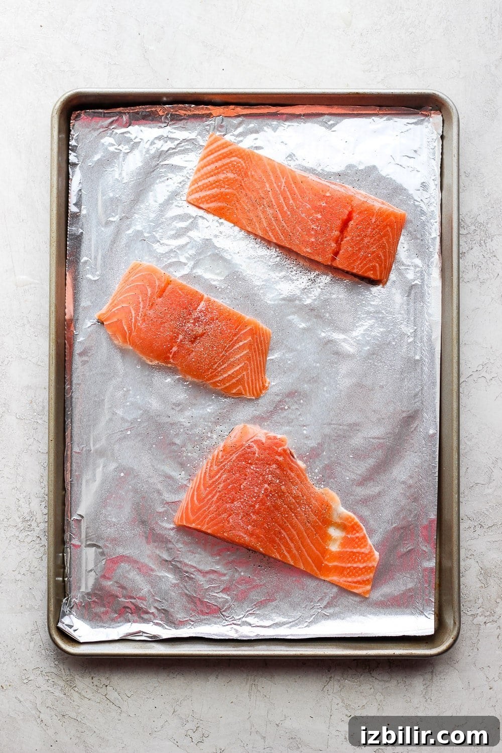 Sheet Pan Salmon Stir-Fry with Roasted Vegetables 4 salmon filets on a sheet pan ready to be broiled