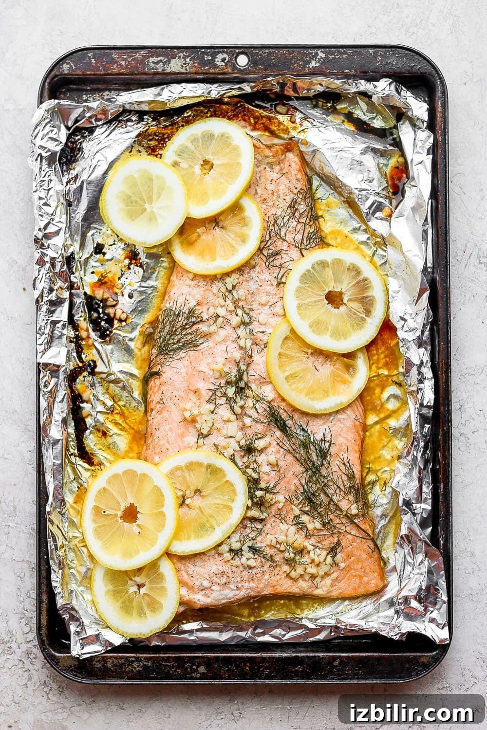large salmon fillet on tin foil with lemons