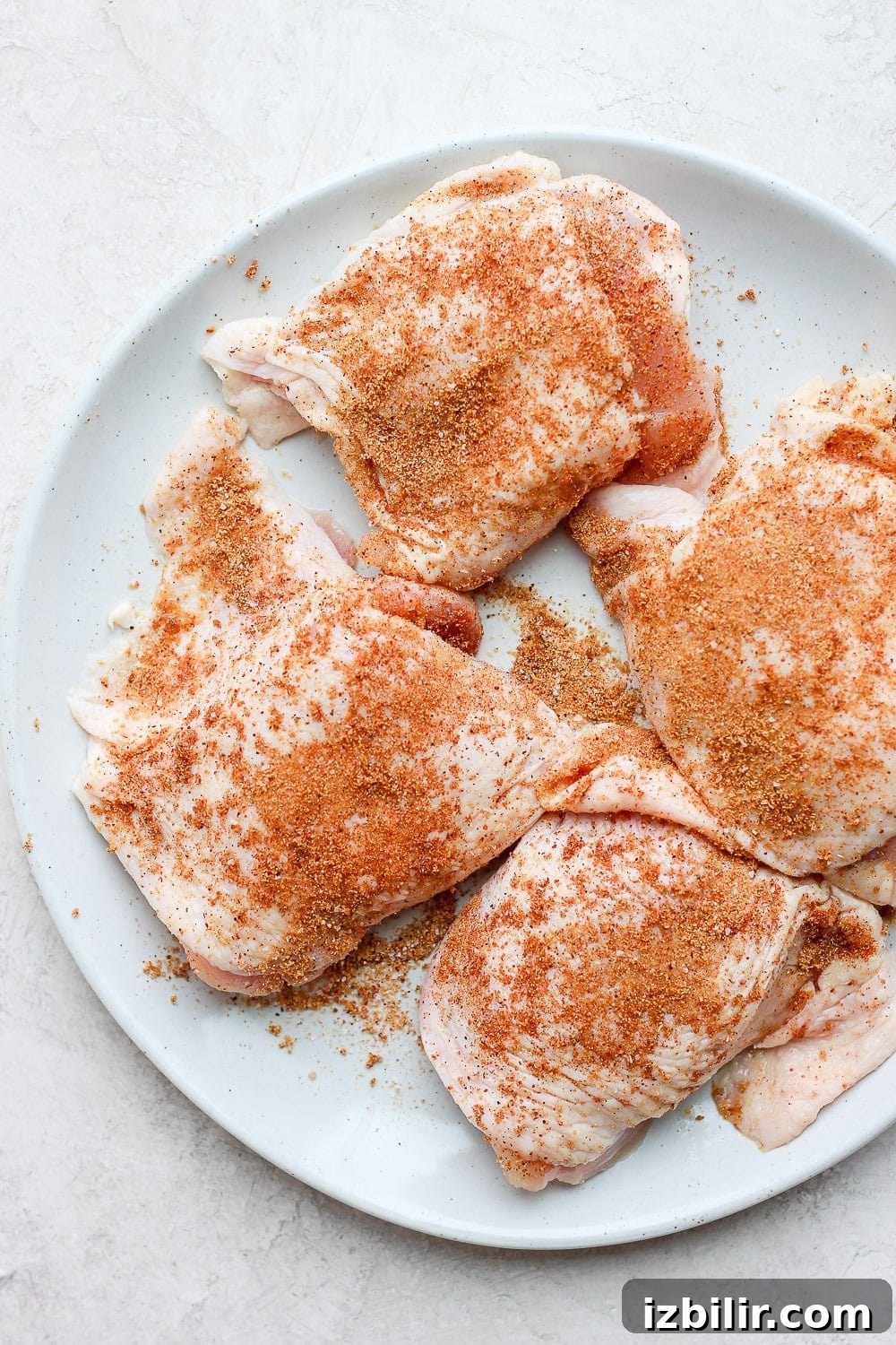 Uncooked chicken thighs on a plate