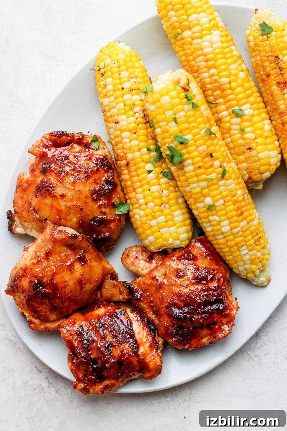 Grilled chicken thighs and corn on a plate