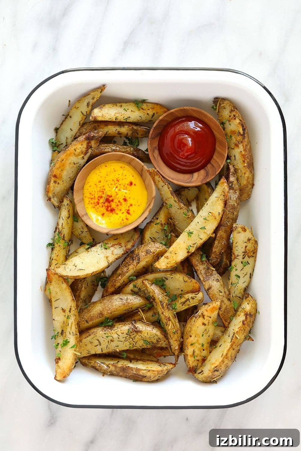Potato wedges in a platter with ketchup and mustard. 