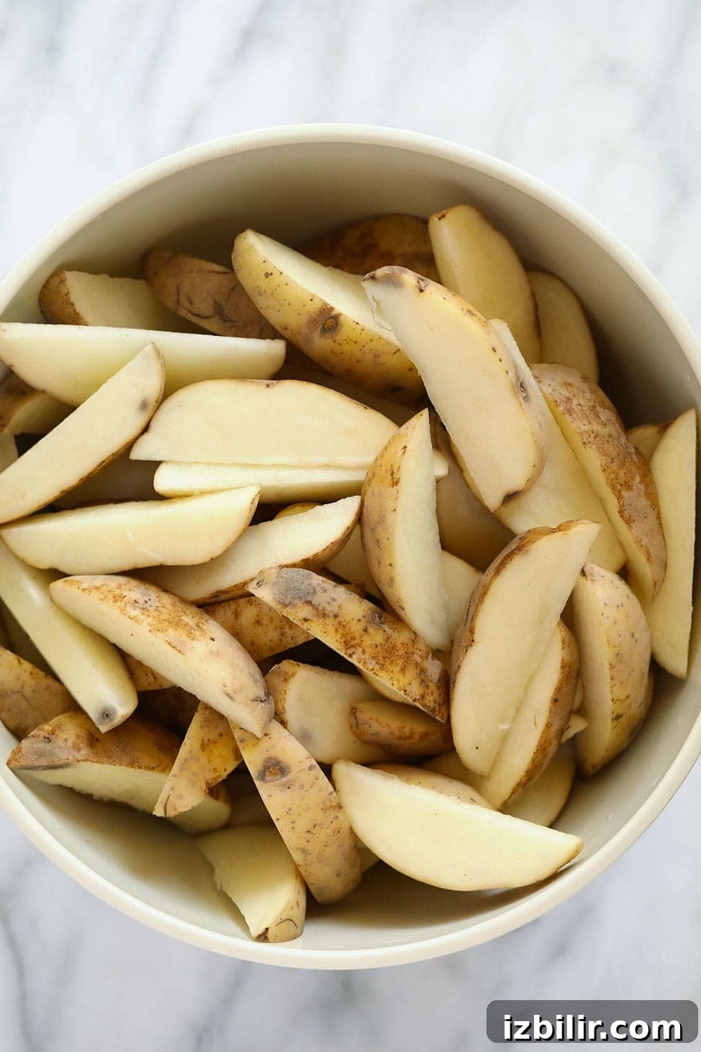 Chopped potato wedges in a bowl. 