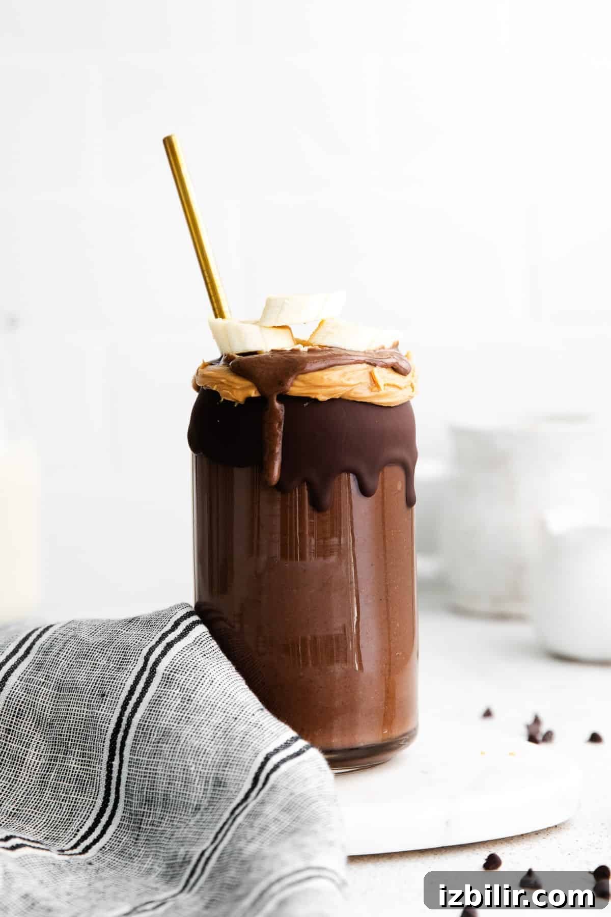 This Chocolate Peanut Butter Banana Smoothie is packed with protein and even has a full serving of greens in it. The best part is, it's healthy and tastes exactly like a peanut butter cup! chocolate peanut butter smoothie with straw