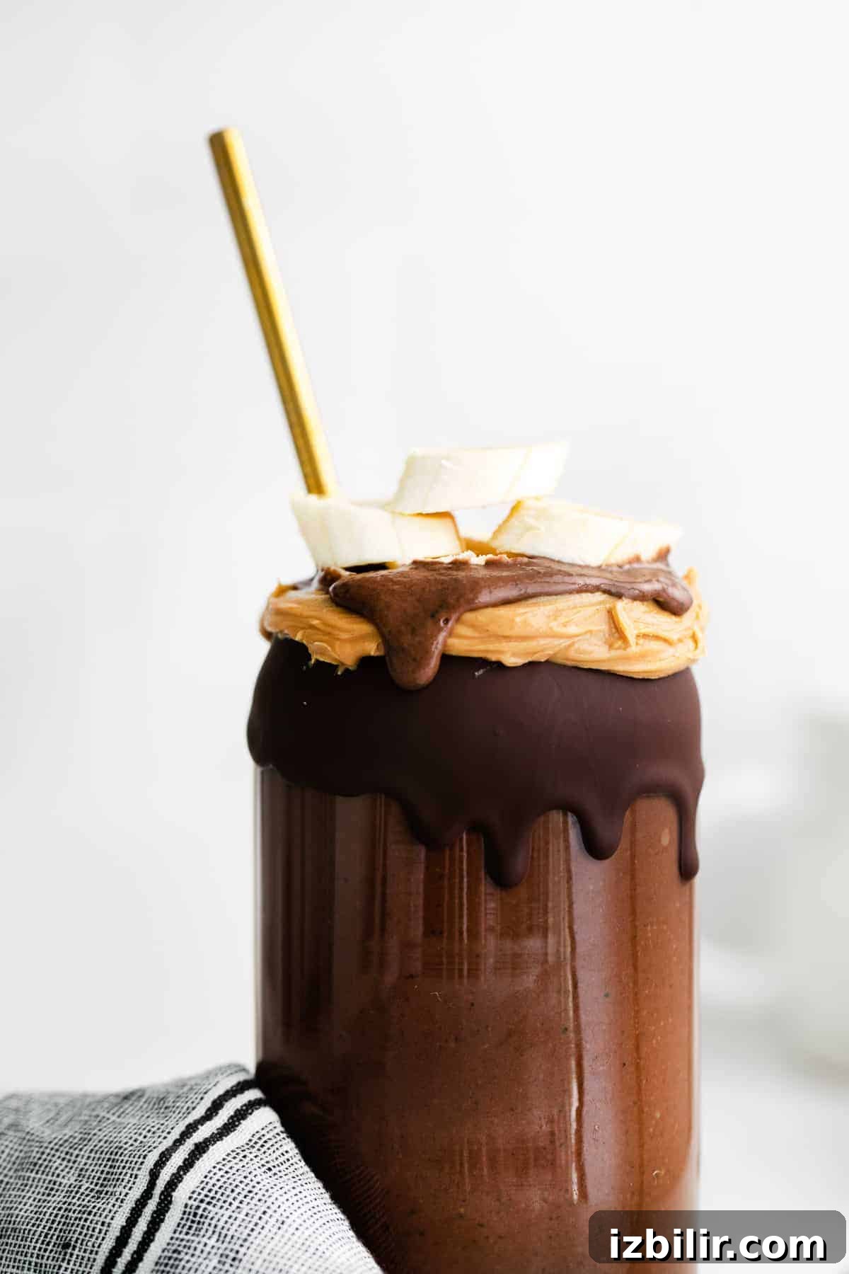 This Chocolate Peanut Butter Banana Smoothie is packed with protein and even has a full serving of greens in it. The best part is, it's healthy and tastes exactly like a peanut butter cup! magic shell on smoothie glass