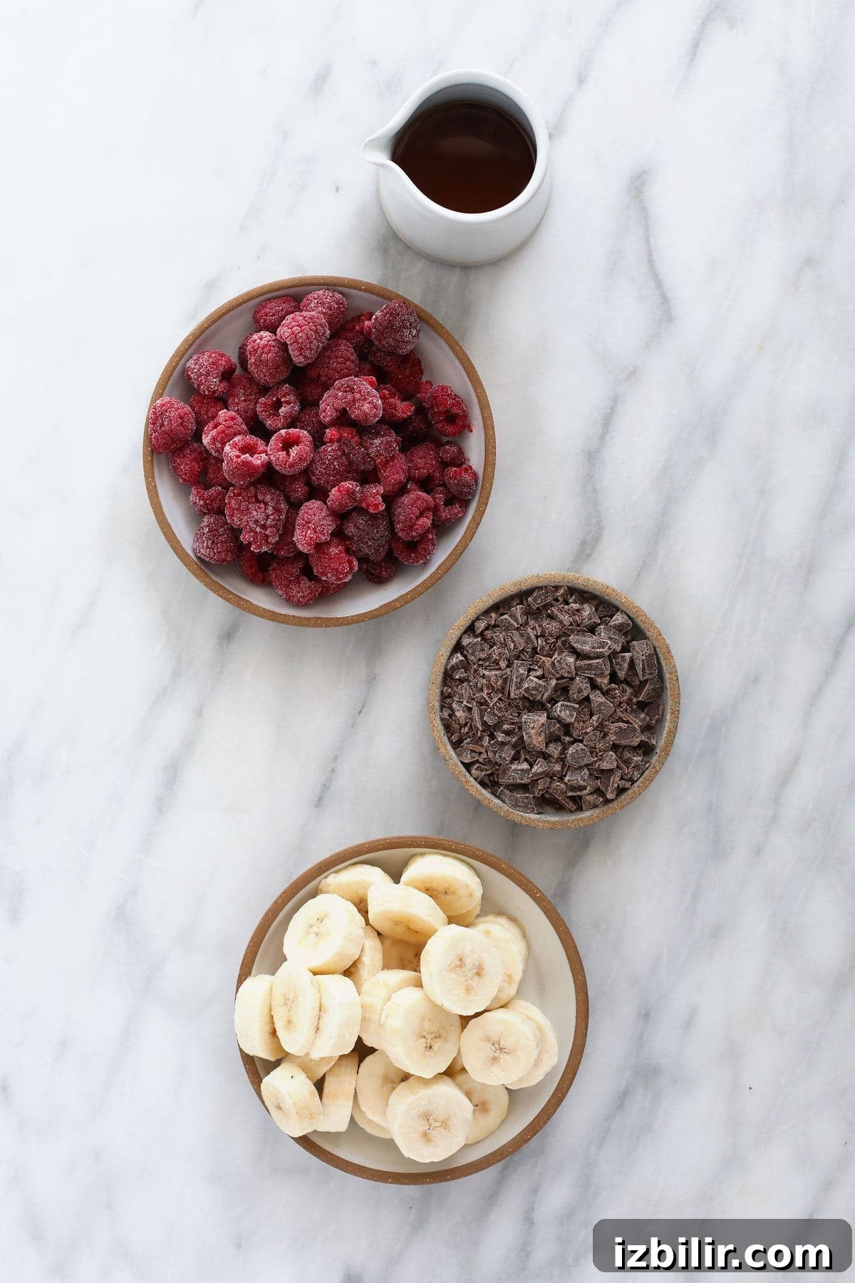 ingredients for raspberry chocolate chunk banana nice cream, ready to be added to a food processor