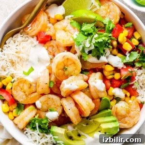 A white bowl with shrimp, rice and vegetables.
