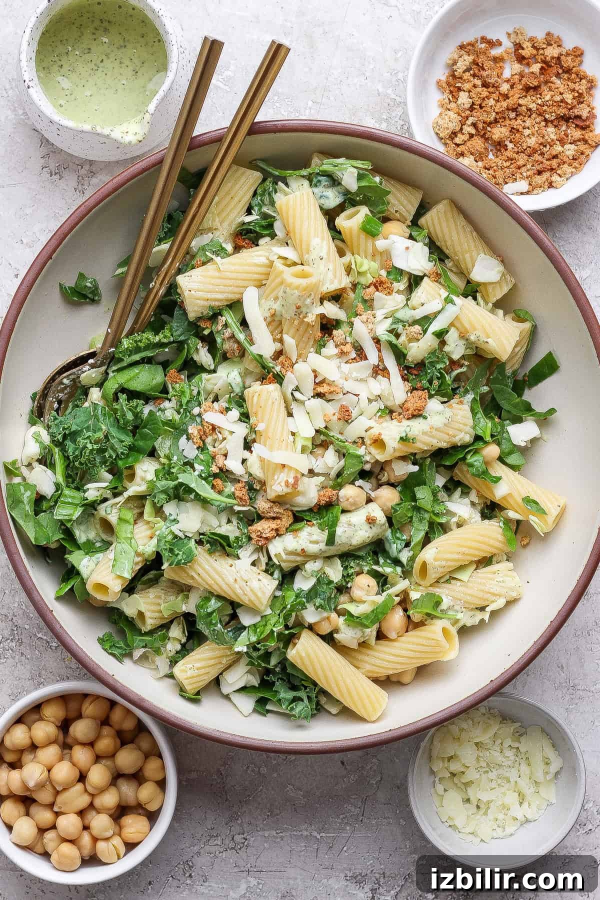 Green Goddess Pasta Salad: 6 Ingredients, No Dressing Needed 2 A bowl of pasta salad with greens, chickpeas, cheese, and crumb topping, surrounded by small bowls of chickpeas, cheese, crumbs, and dressing.