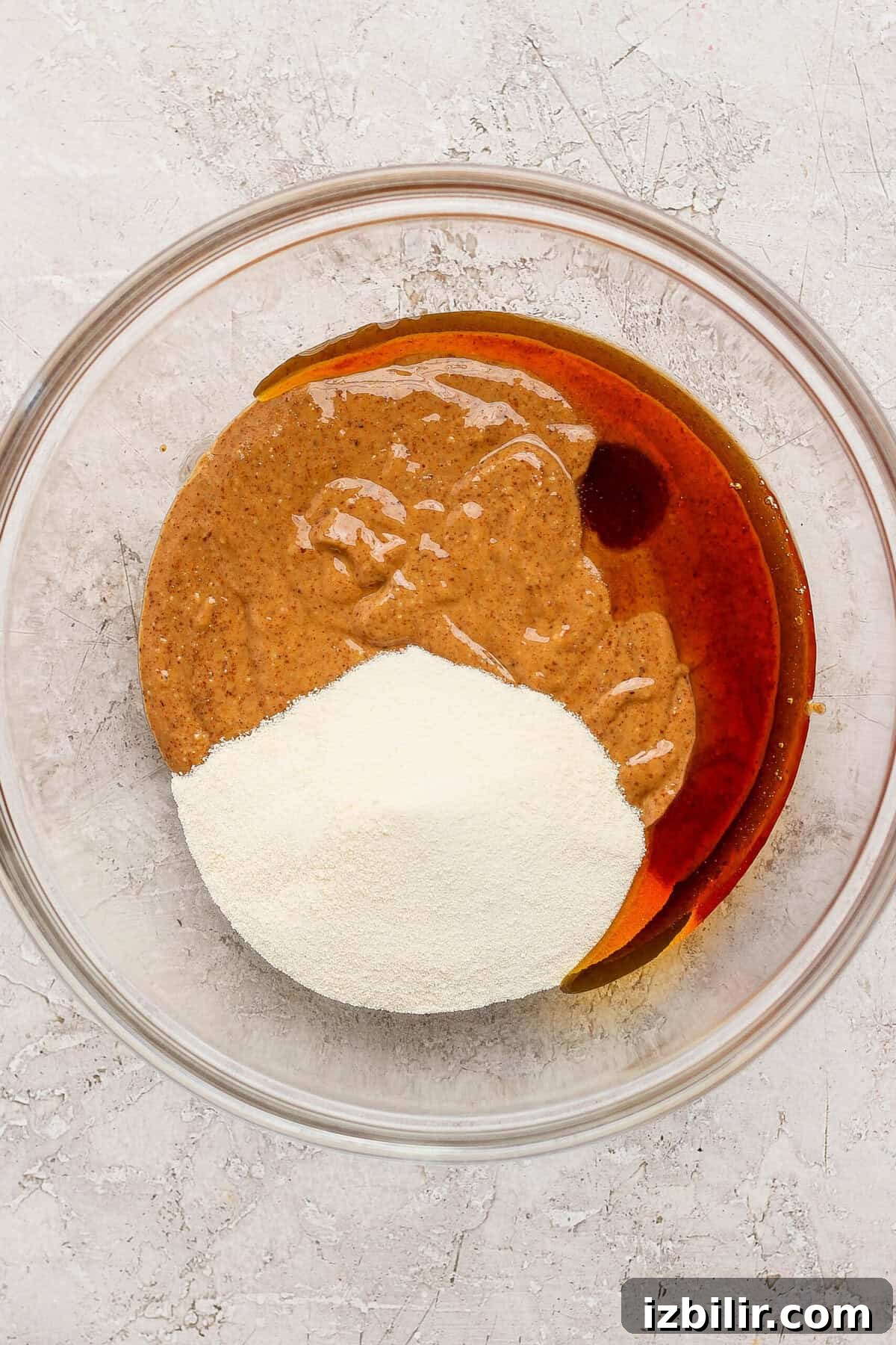 No-Bake Thin Mint Protein Bites Recipe 3 mixing almond butter maple syrup and protein powder in a glass bowl for thin mint protein bites