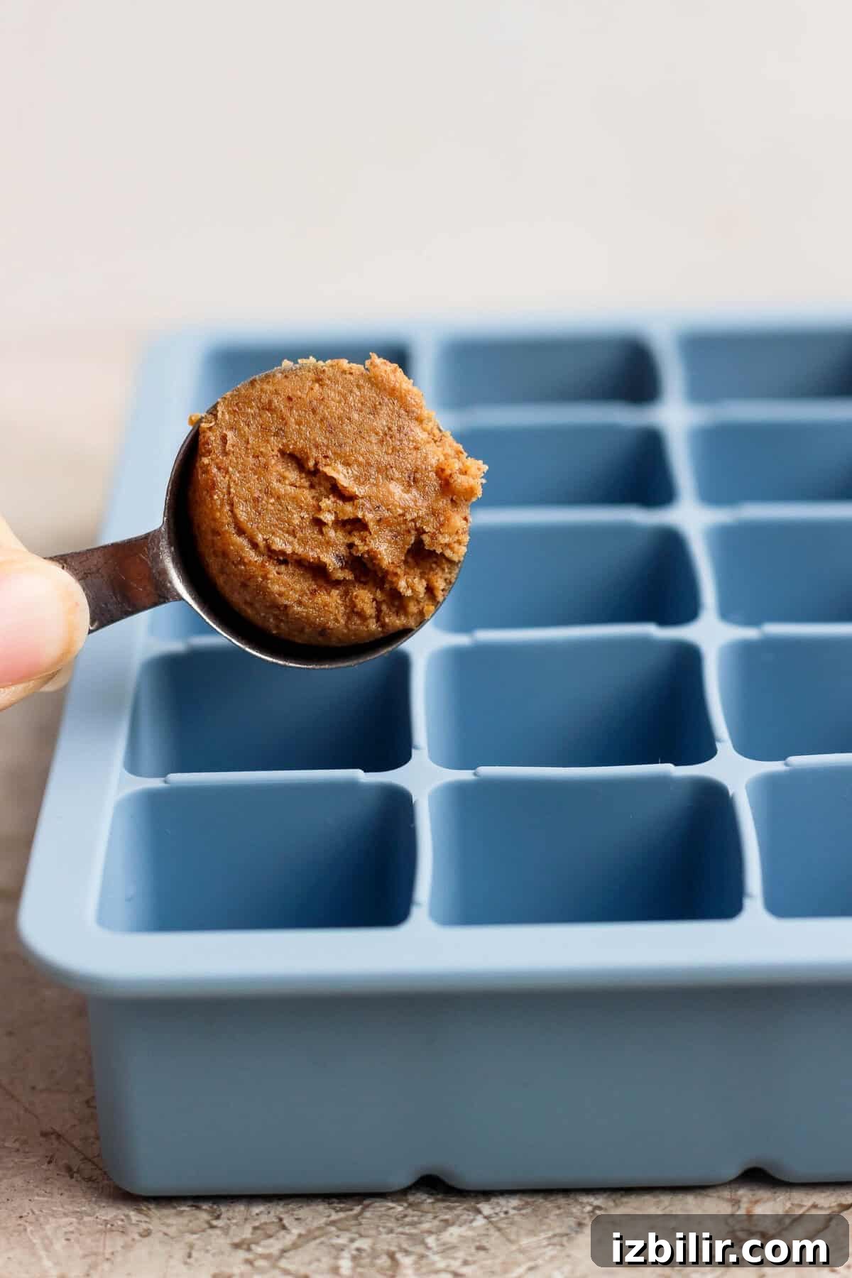 No-Bake Thin Mint Protein Bites Recipe 4 spooning protein bite mixture into a blue silicone ice cube tray