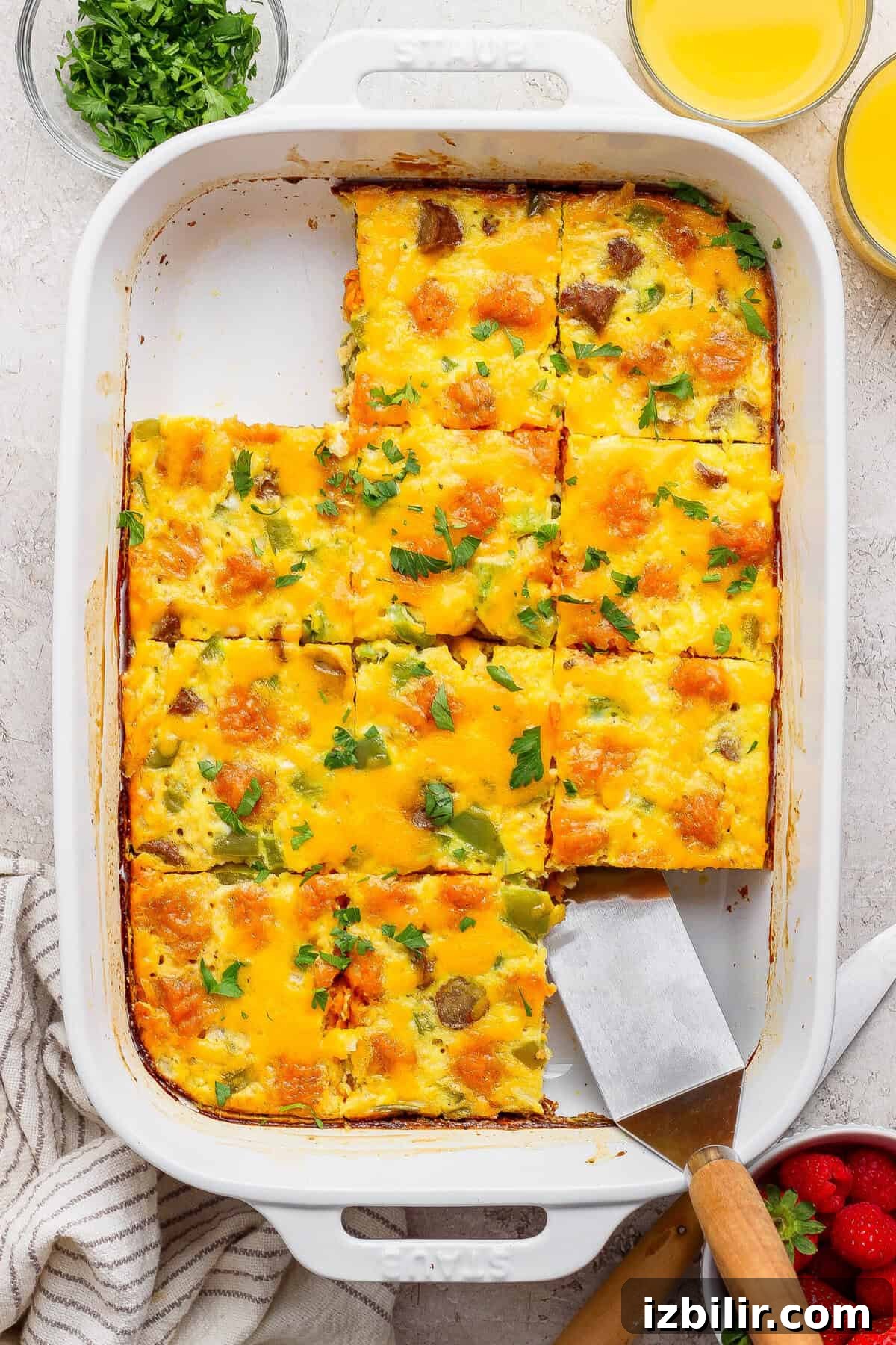 sweet potato breakfast casserole sliced into squares with a piece being lifted out