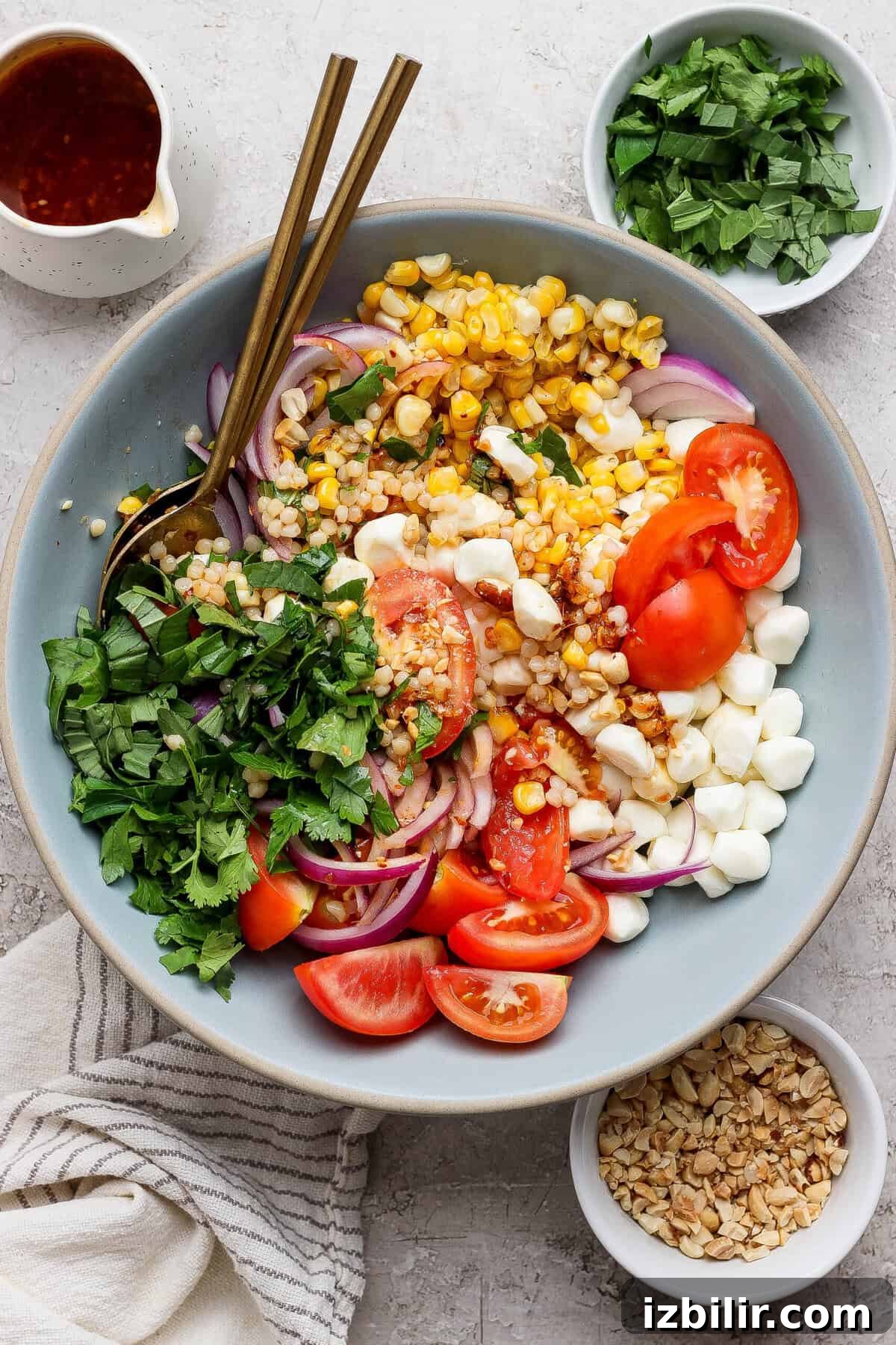 Zesty Summer Corn and Tomato Salad with Chili Crunch Dressing 5 finished corn tomato salad with mozzarella pearls corn and tomatoes styled with peanuts and dressing