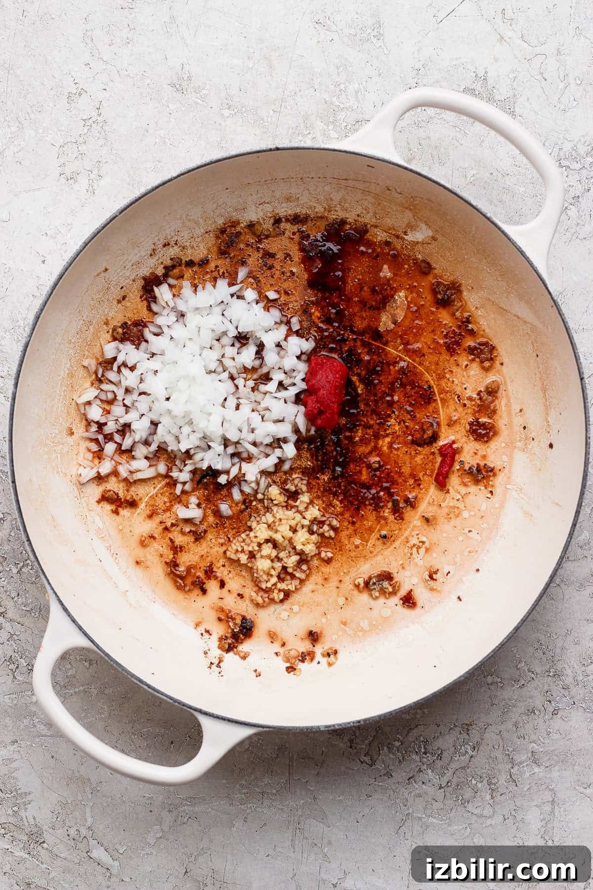 Bite-Sized Cottage Cheese Meatballs with Pasta 5 Minced onion, garlic, and tomato paste cooking in a white skillet for mini meatball pasta.