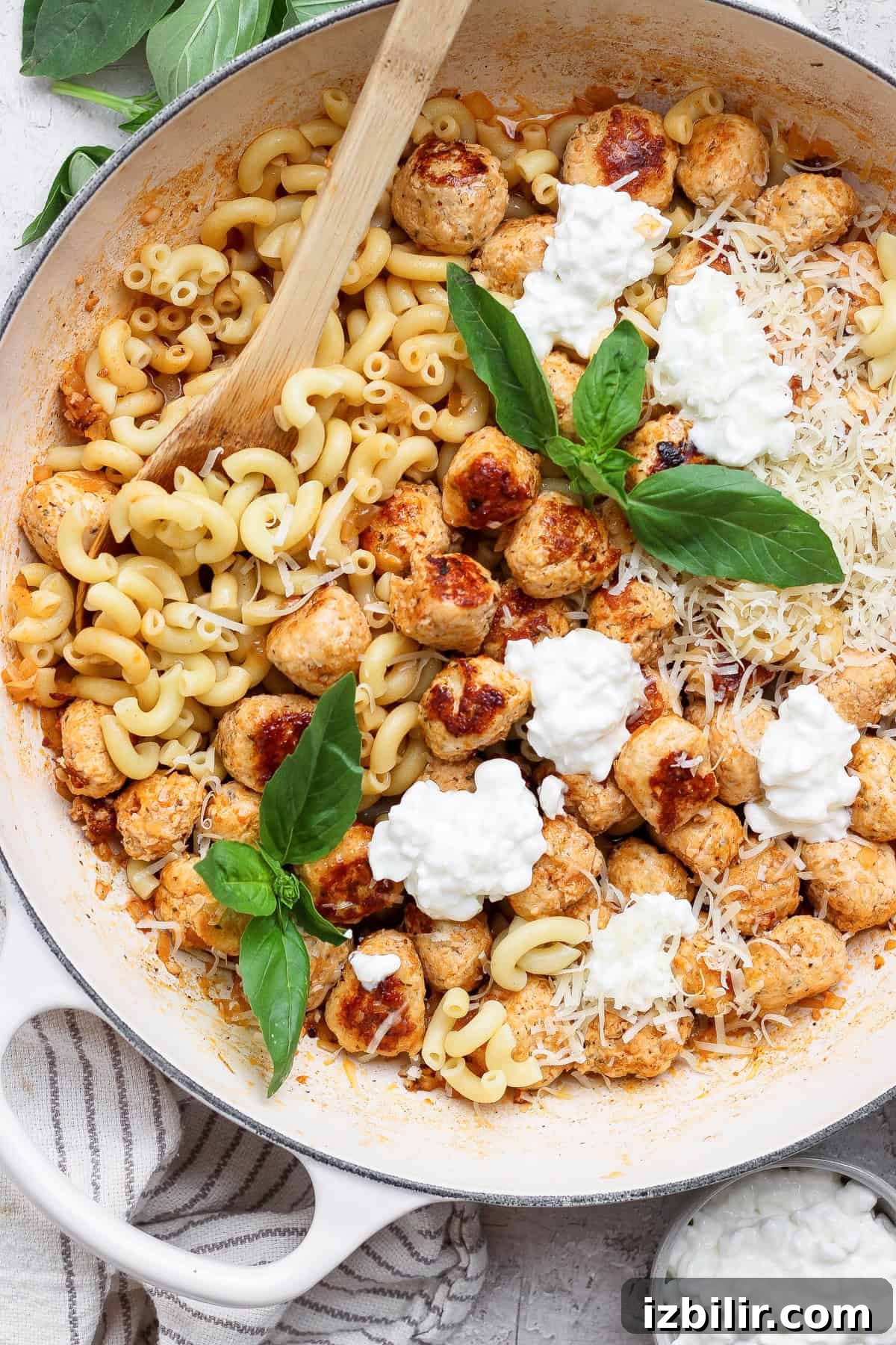 Bite-Sized Cottage Cheese Meatballs with Pasta 7 Overhead view of mini chicken meatball pasta topped with cottage cheese, Parmesan, and fresh basil.