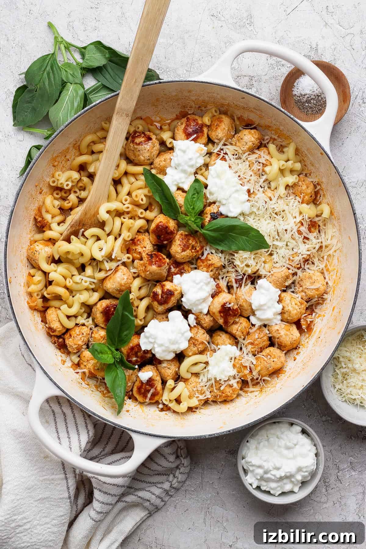 Bite-Sized Cottage Cheese Meatballs with Pasta 8 Finished mini cottage cheese meatball pasta in a white skillet with a wooden spoon.