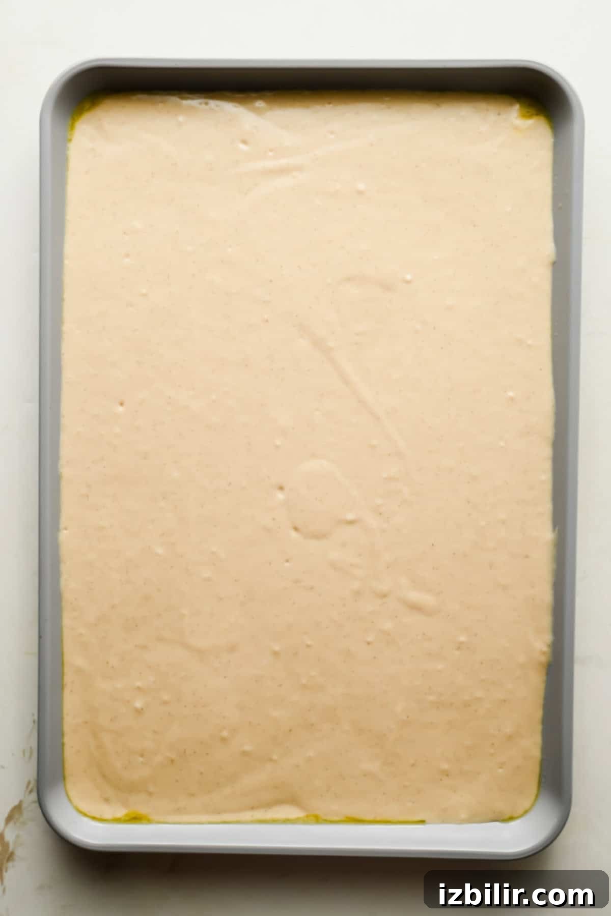 Pancake batter spread evenly in a greased quarter sheet pan.