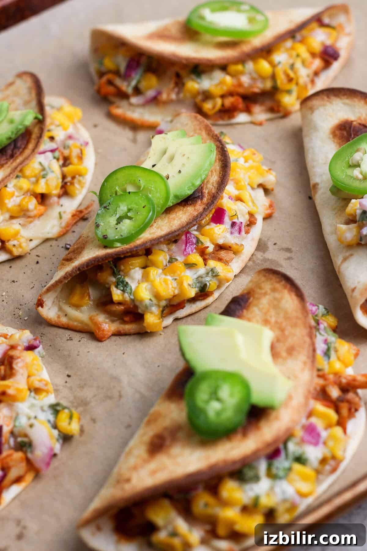 Oven-Baked Street Corn Chicken Tacos 2 Crispy baked chicken tacos filled with creamy street corn salad and topped with avocado and jalapeño.