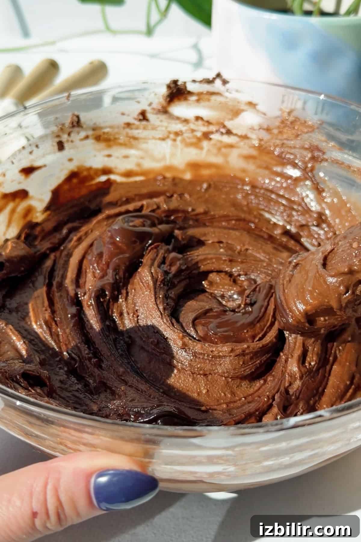 Fudgy 2-Ingredient Cottage Cheese Brownies 3 Thick chocolate brownie batter made with blended cottage cheese being stirred in a glass mixing bowl.