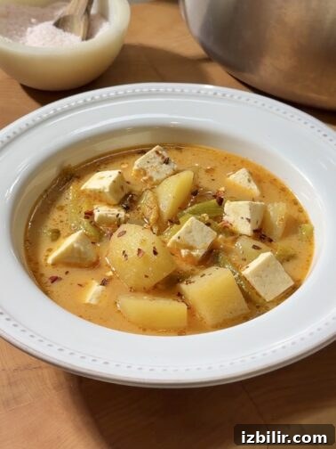 Bowl of Caldo de Queso with cheese and chile strips
