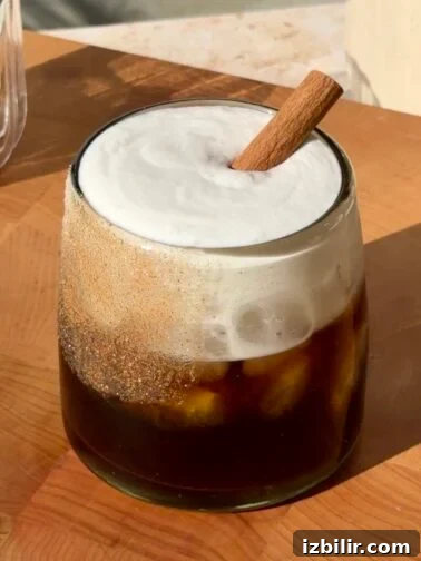 Horchata White Russian served in a glass with a cinnamon stick and sugar rim