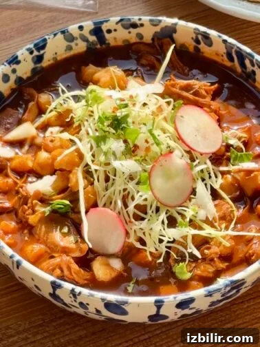 Bowl of Pozole Negro with garnishes